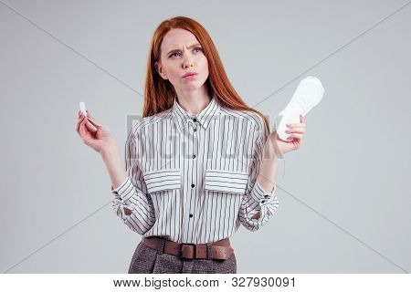 Closeup Photo Of Young Redhead Businesswoman In Striped Shirt Holding Hygiene Pad Choosing Tampon St