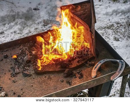 Red Fire Blazes Inside Of Coal Forge.  Blacksmith Traditional Works With Hot Metal  To Form Horse Sh