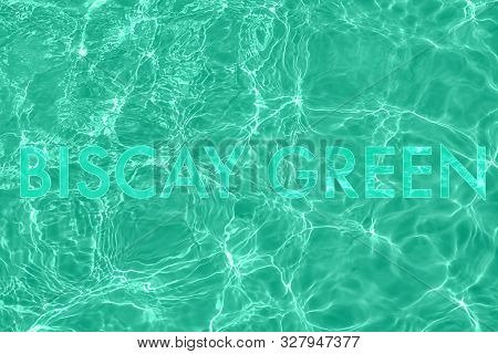 Trendy Transparent Mint Colored Text On Calm Clear Water Surface. Color Trend Concept.