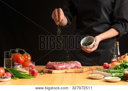 Pork Steak And Green Herbs From The Chef In The Background. Hori