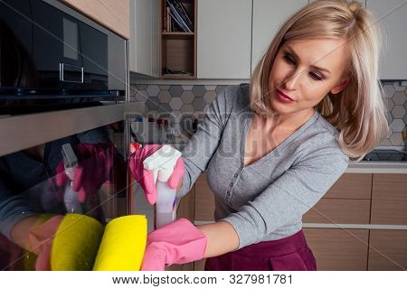 Young Woman Cleaning Oven In The Kitchen