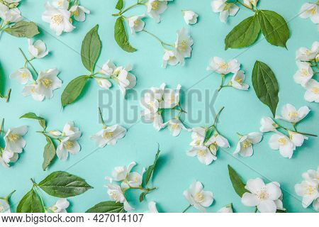 Pattern Of Bud Jasmine And Leaves Scattered On A Green Background, Overhead View. Flat .pattern Of B