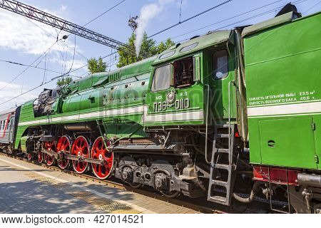 Green Retro Steam Locomotive At The Railway Station On A Sunny Day