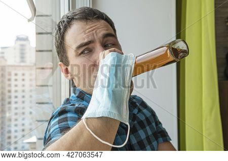 Alcoholism, Alcohol Addiction And People Concept - Male Alcoholic With Bottle Of Rum At Home. An Une
