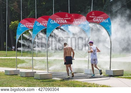 Vilnius, Lithuania - July 17 2021: Athletes Running Through Water Mist To Cool Down During A Competi