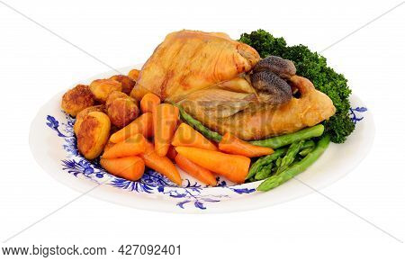 Roasted Whole Guinea Fowl With Roast Potatoes And Fresh Vegetables Isolated On A White Background