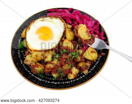 Corned Beef Hash Meal With A Crispy Fried Egg And Pickled Red Cabbage Isolated On A White Background