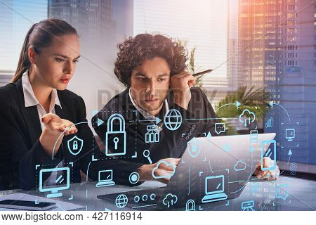 Two Thoughtful Business People With Laptop, Blue Glowing Information Protection Icons. Padlock And B