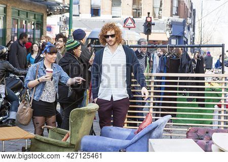 London, Uk - November 2019, Fashionable Redhead Curly Young Man In A Blue Blazer And A Girl In A Sho