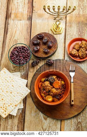 Jewish Dish Cholent With Meat Ingredients And Menorah On The Table. Vertical Photo