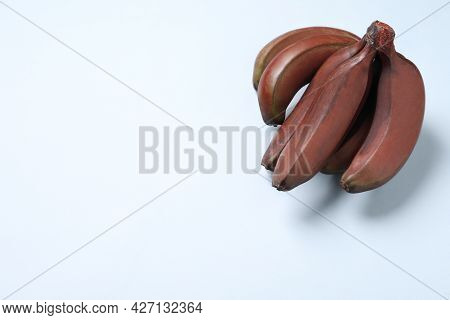 Tasty Red Baby Bananas On Light Background, Top View. Space For Text