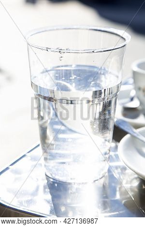 Transparent Plastic Glass With Non Alcoholic Liquid On Metal Table In Outdoor Bar. Drinking Water Pr