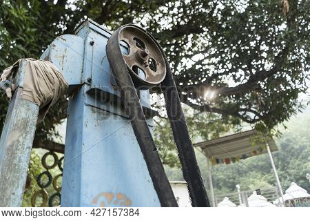 Old Rusted Machinery Painted In Blue Color Kept Under Sunglight.