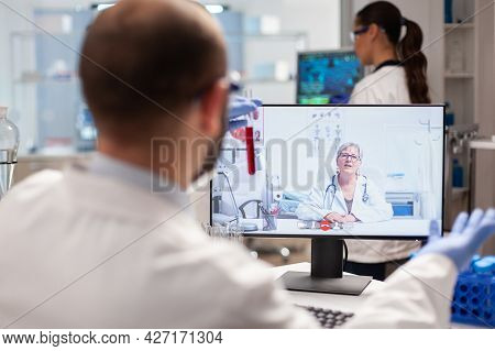 Chemistry Researcher Discussing About Virus Vaccine With Doctor During Video Conference Holding Samp