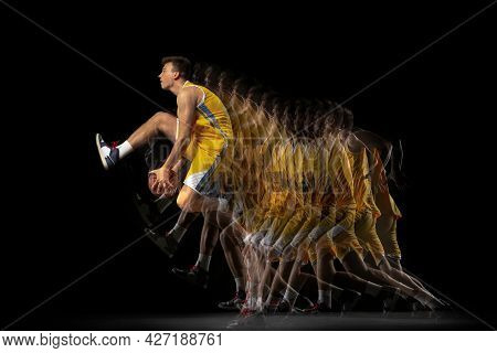 Portrait Of Young Basketball Player Training With Ball Isolated On Dark Background With Stroboscope 