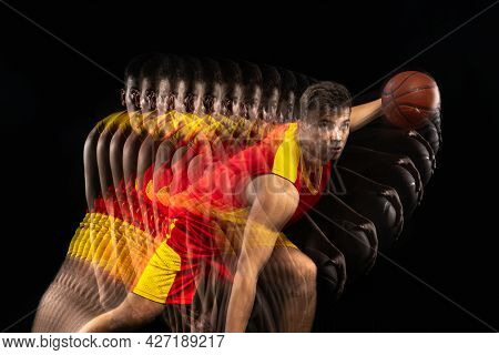One Young Basketball Player Training With Ball Isolated On Dark Background With Stroboscope Effect. 