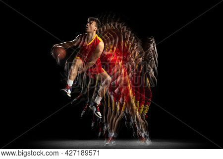 Power And Speed. One Young Basketball Player Training With Ball Isolated On Dark Background With Str