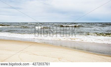 Sea Waves On The Beach And Overcast Sky