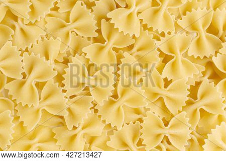 Farfalle Bow Tie Whole Wheat Yellow Pasta. Butterflies Shape Uncooked Food Background. Italian And M