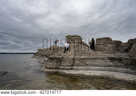 June 6, 2021 - Borgholm, Sweden: People Enjoy Beautiful Limestone Formations With A Dramatic Sky In 