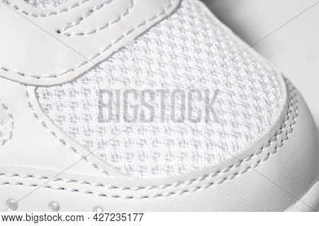 Macro Photo Of White Sneakers. Close-up Photo Of A Round Nose Of A Childrens Sports Leather Sneaker 