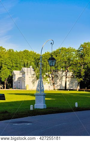 A Beautiful Street Lamp Against The Background Of A Green Meadow And Blue Sky In The Elaginsky Park 