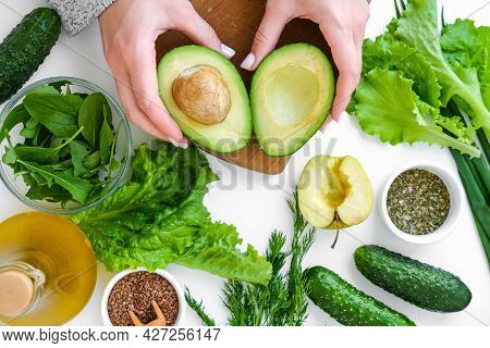 Woman Cooking Salad Of Fresh Green Vegetables And Herbs. Raw Food Concept. Vegan Menu. Cooking Healt
