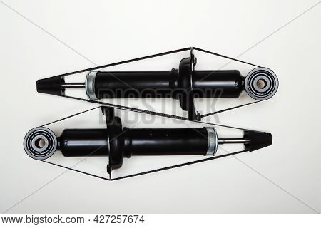 Two New Shock Absorbers For The Car Lie On A Flat Surface. A Set Of Spare Parts For The Repair Of Th