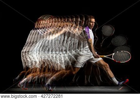 Portrait Of Young Man, Male Tennis Player In Motion And Action Isolated On Dark Background. Strobosc