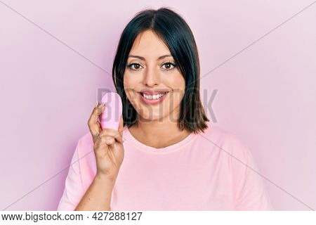Young hispanic woman using facial exfoliating cleaner looking positive and happy standing and smiling with a confident smile showing teeth 