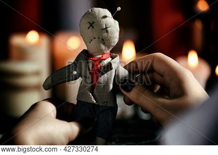 Woman Holding Voodoo Doll With Pins Indoors, Closeup. Curse Ceremony