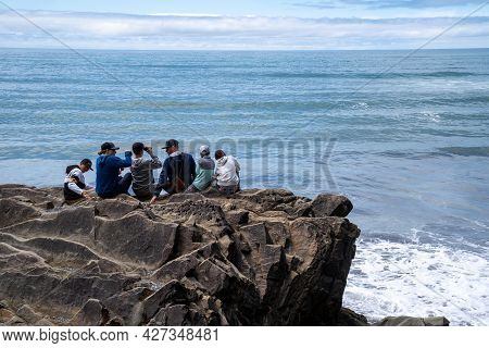 Washington, Usa - July 8, 2021: A Family Of Five Sits On A Rock Outcropping At Kalaloch Beach In Oly