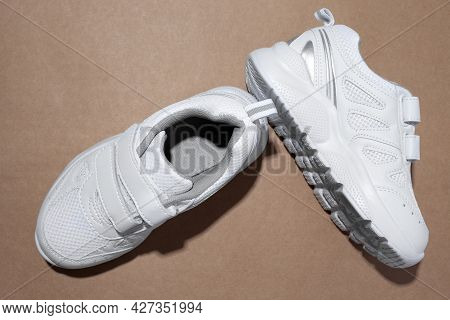 Top View White Unisex Running Shoes With Velcro Fasteners For Easy Footwear With Hard Shadows Isolat