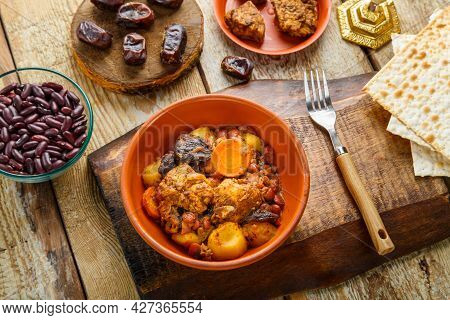 Jewish Dish Chelnt With Meat On A Stand Next To Matzo And Ingredients. Horizontal Photo