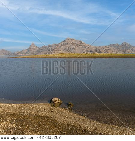 Square Format Of Jawai Dam Landscape With Water And Blue Sky And Clouds In Rajasthan India