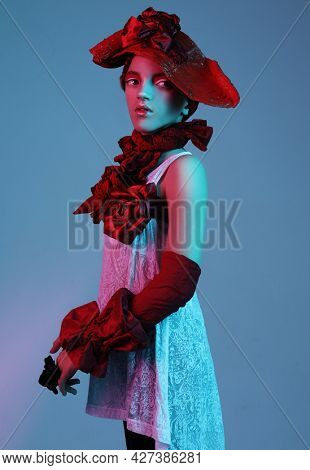 Beautiful child girl in a stylish fashionable suit - red hat, scarf, bracelet, neon light, fashion concept