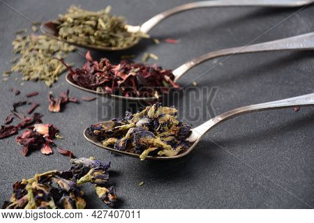Various Kinds Of Dry Tea Bancha Green, Hibiscus, Butterfly Pea Flower Tea In Spoons On The Table