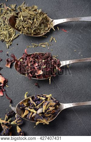 Various Kinds Of Dry Tea Bancha Green, Hibiscus, Butterfly Pea Flower Tea In Spoons On The Table