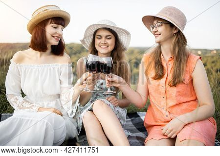 Hen Party. Girls Frienship And Fun. Group Of Three Young Women In Hats And Dresses, Enjoying Tasty F