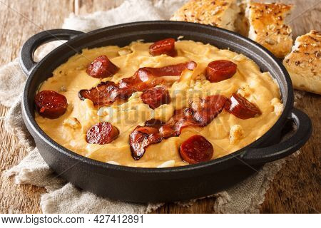 Pea Flour Gachas Manchegas With Paprika Served With Bacon And Chorizo Close-up In A Plate On The Tab
