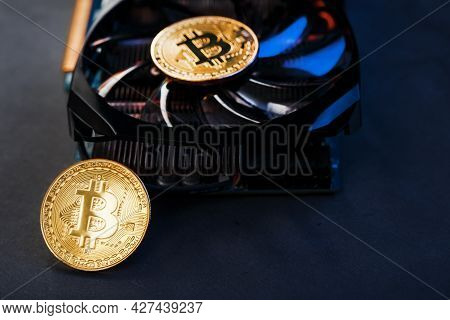 Gold Bitcoins On A Video Card With A Blue Backlight In The Style Of Cyberpunk.
