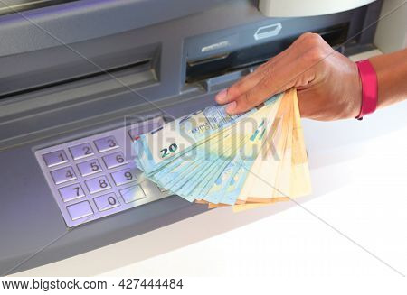 Euro Banknotes Just Withdrawn From The Atm And The Hand That Picks Them Up With The Numeric Keypad T