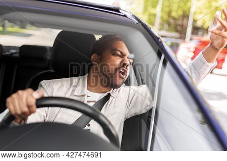 transport, vehicle and people concept - angry indian man or driver driving car and gesturing