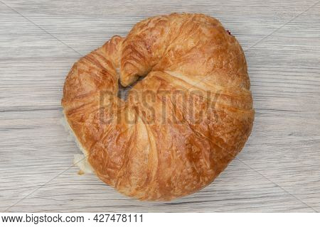 Overhead View Of Plain Croissant Roll Is Textured With Flakey Brust For A Baked Treat Delight.