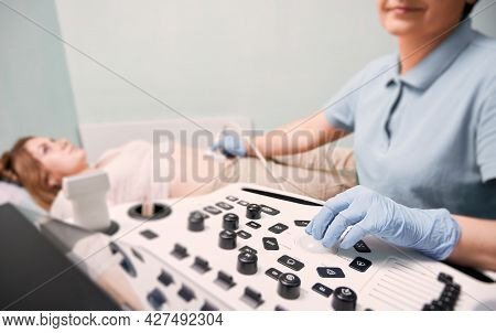 Focus On Doctors Hand In Sterile Gloves Examining Female Patient With Ultrasound Scanne. Sonographer