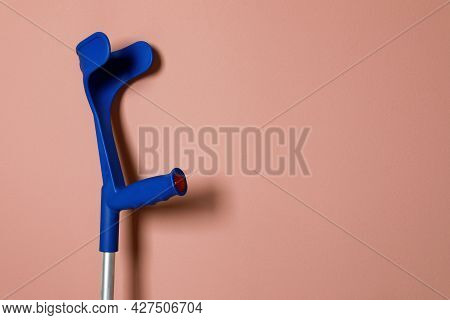 Elbow Crutch On Pale Pink Background. Space For Text