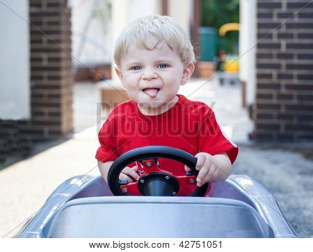 Todder menino brincando com carro de brinquedo grande