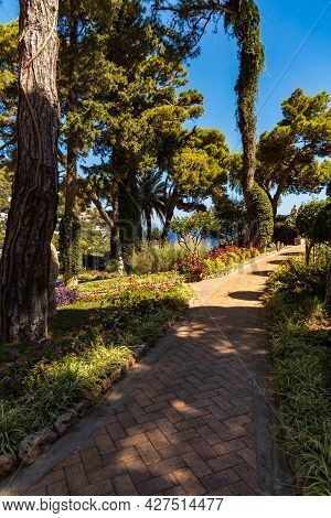 Small Path In Giardini Di Augusto Full Of Colorful Trees And Flowers