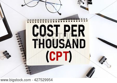 Cost Per Thousand, Text On Notepad. On A White Background Near The Stationery