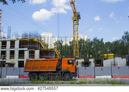 Mobile Crane At Construction Site. The Truck Is Parked Next To A Construction Site. Construction Of 